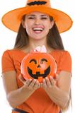 Closeup on Halloween bucket with sweets in woman hands