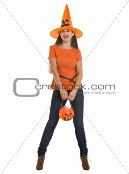 Happy woman holding Halloween bucket with sweets