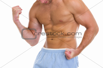 Closeup on sports man showing muscles of torso and biceps