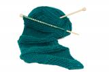 Scarf on knitting needles with a ball of wool
