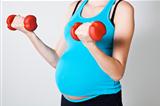 Pregnant woman exercising with dumbbells