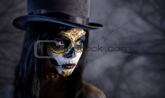 Sugar skull girl in tophat in the forest 