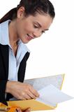young businesswoman holding file looking pleased