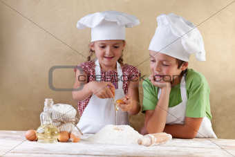Kids with chef hats preparing tha cake dough