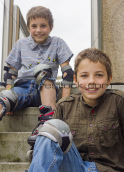 two smiling teenage boys in roller-blading protection kits