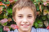 Portrait of smiling teenage boy at bush