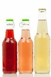 Three bottles with different colored drinks