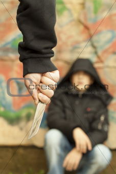 Boy looks at a man with a knife