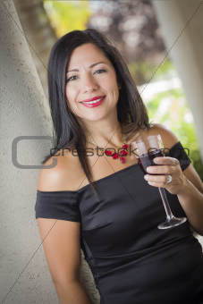 Attractive Hispanic Woman Portrait Outside Enjoying a Glass of Wine.