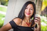 Attractive Hispanic Woman Portrait Outside Enjoying a Glass of Wine.