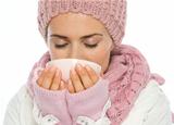 Woman in knit scarf, hat and mittens drinking hot beverage