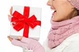 Closeup on Christmas present box in hand of woman in winter clothing