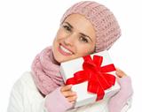 Happy woman in knit winter clothing holding Christmas present box