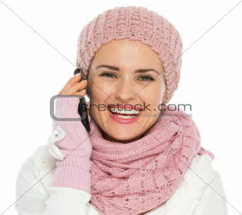Happy woman in knit winter clothing making phone call