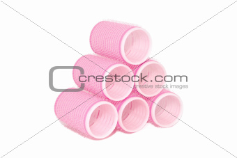 Six pink velcro rollers stacked in a pyramid