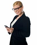 Smiling female business executive messaging