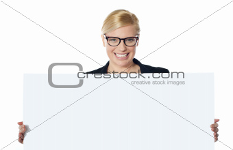 Portrait of happy woman showing blank placard
