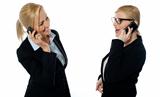 Businesswomen communicating via mobile phones