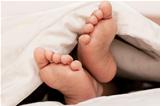 Baby feet under a blanket