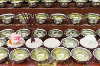 small bowls with water and rice around a temple