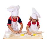 Children making cookies dressed as chefs