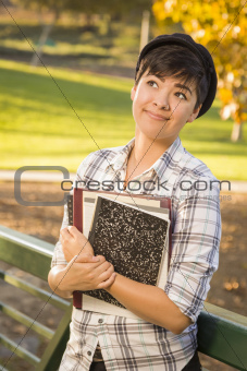 Outdoor Portrait of a Pretty Mixed Race Female Student Holding Books Looking Away.