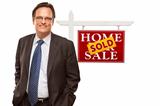 Businessman in Front of Sold Home For Sale Real Estate Sign Isolated on a White Background.