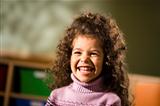 Happy female child smiling for joy in kindergarten