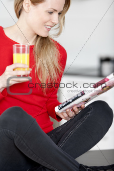Young woman reading a magazine at home