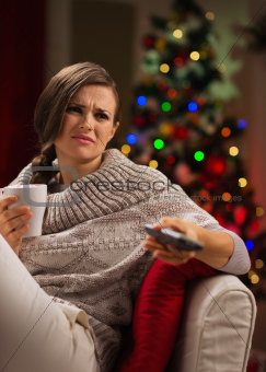 Young woman with cup of hot beverage get bored looking TV