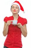 Young woman in Christmas hat enjoying cup of coffee