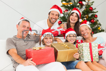 Happy family at christmas holding gifts on the couch