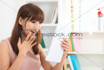 Surprise Asian female with tablet
