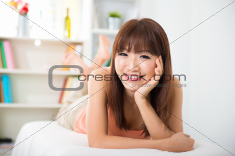 Asian woman lying on sofa