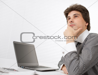 young business man thinking while working on laptop