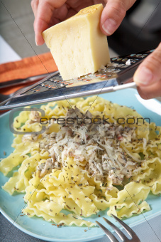 grating cheese on pasta