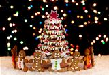 Happy gingerbread people around the christmas tree