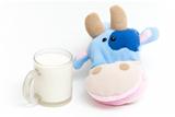 Isolated soft hand puppet cow with glass of milk