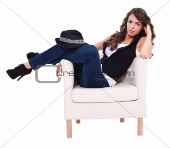 Sexy brunette sitting in armchair
