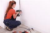 Woman drilling hole in wall