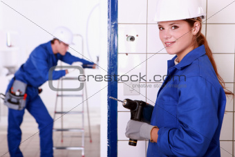 Female electrician with a power drill