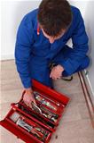 Artisan knelt by red tool box