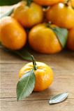 ripe juicy tangerine, orange mandarin  with leaves on  wooden table