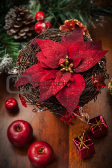 Christmas flower with decoration on wooden table