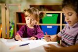 Children and fun, two preschoolers drawing in kindergarten