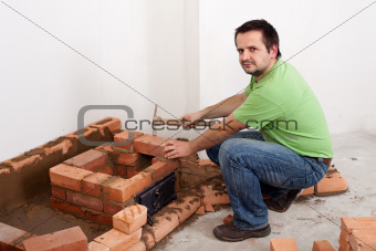 Worker building a brick stove