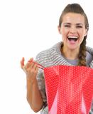 Smiling woman in sweater opening shopping bag