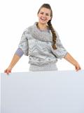 Smiling woman in sweater holding blank billboard