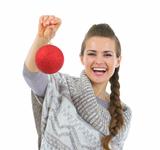 Smiling woman in sweater holding Christmas ball