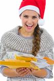 Happy woman in Santa hat holding pack of Christmas letters